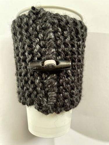 Hand knitted black coffee koozie with wood toggle button for decoration.