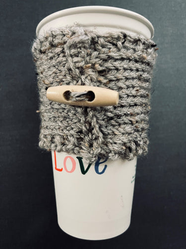 Hand knitted gray coffee koozie with wood toggle button for decoration.