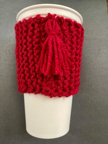 Hand knitted red scarf coffee koozie with red tassel.