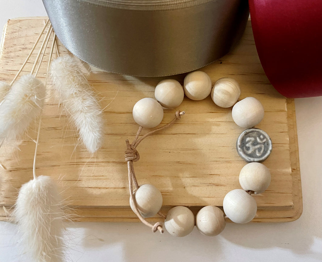 Stackable natural wood bead bracelet with stone ohm sign bead on leather cord