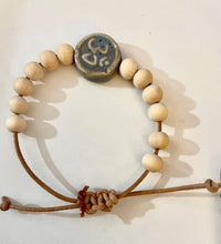 Load image into Gallery viewer, Stackable natural wood bead bracelet with stone ohm sign bead on leather cord

